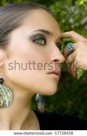Adult female posing with turquoise jewelry on a bright day