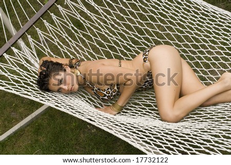 Brunette posing with her butt in the air while laying on a white hammock