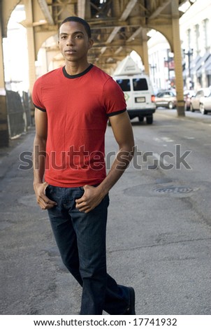 Good looking African-American male in blue jeans and t-shirt standing outside