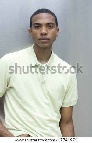 Stylish photo of a black male in a yellow collared shirt on a sunny day