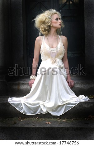 Beautiful photo of a tall woman in a white dress with a dark background