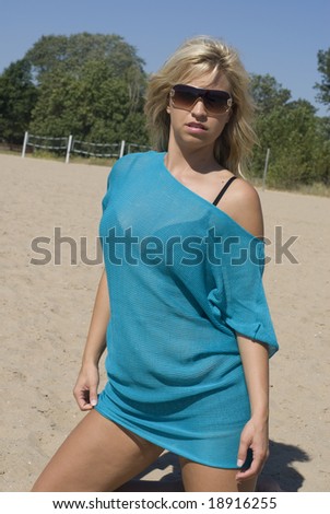 Cool looking blonde model in bathing suit cover-up and dark sunglasses