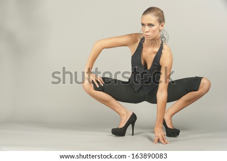 A young female model experimenting with fashionable elements in a studio setting.