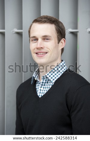 A happy and attractive young man looking at the camera on a sunny day.