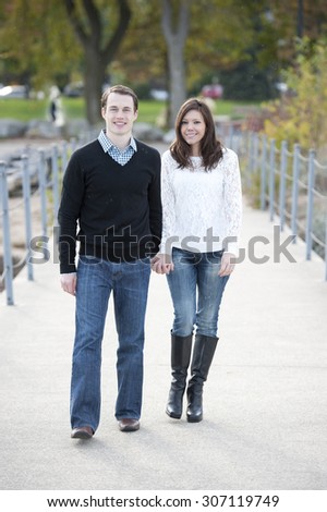 Happy young couple walking on the pier on a sunny day.