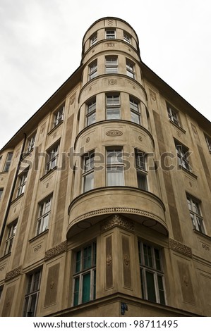 An angle shot emphasizing the cylinder shape of the corner to a classical architecture building in Prague.