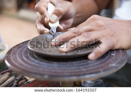 hands of a potter, creating a plate on the circle