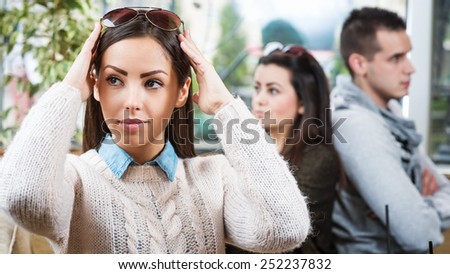 Portrait of young beautiful female in cafe with couple in the background who is in a life raft.