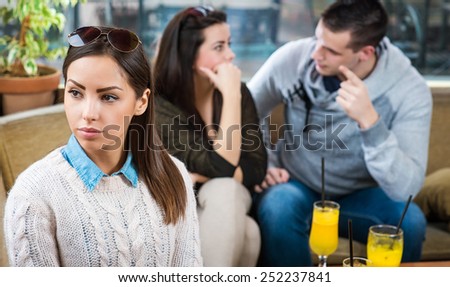 Portrait of young beautiful female in cafe with couple in the background who is in a life raft.