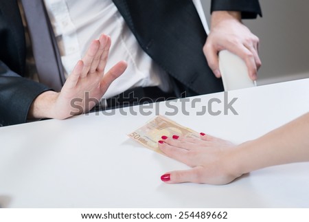 Businessman refusing the money offered by business woman in office, no corruption.