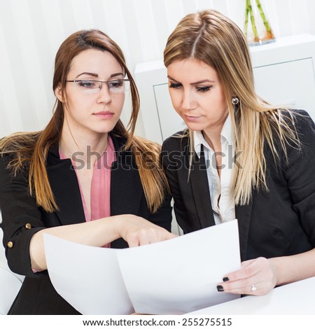 Business meeting, showing contract document, casual conversation at office, two beautiful females.