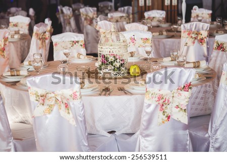 Wedding table decoration in restaurant. Bird cage, vintage.