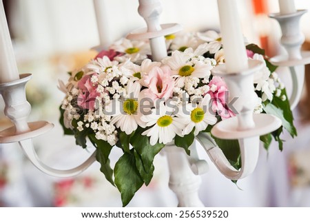 Wedding table setting decoration, candle holder, white candle, flowers.