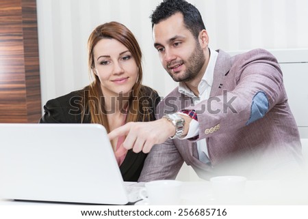 Young business people working on lap top. Office. Man showing to woman something on lap top.