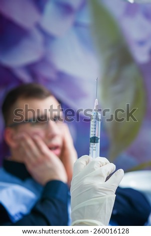 Vaccine at dentist office, shallow depth of field, scary patient in background.