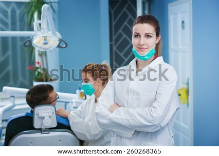 Portrait of beautiful female dentist at busy dentist office. Empty space for text sample.