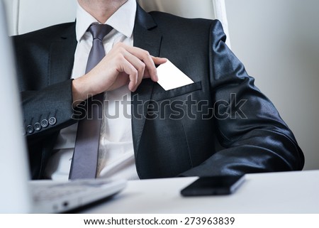 Businessman putting visit card in the pocket.