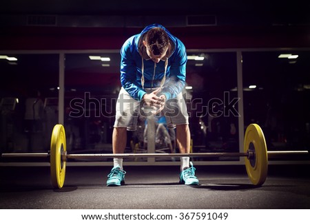 Cross fit weightlifter preparing for training. Shallow depth of field, selective focus on hands and dust.
