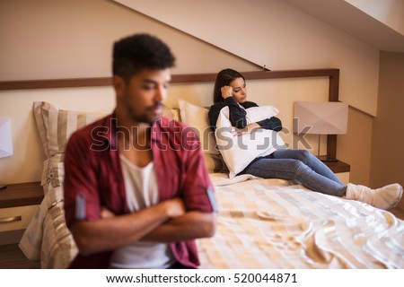 Couple not speaking to each other in bedroom.