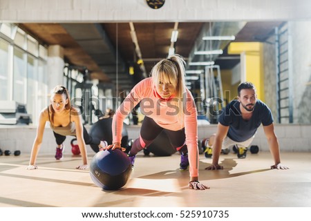 Group of athletes doing push ups at gym.
