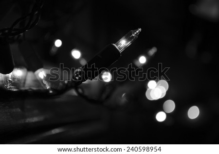 String of lit Christmas lights in the window with bokeh