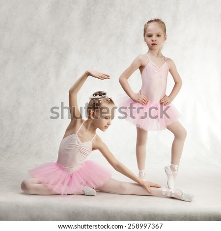 Two little girls - ballerinas sitting in the tutu on the floor