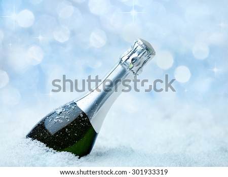 Christmas champagne immersed in snow and frost sparkles