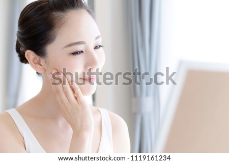 Skin care concept. Young asian woman checking her skin.