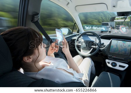 woman using smart phone in autonomous car. self driving vehicle. autopilot. automotive technology.