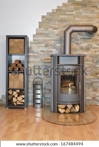 Wood Fired Stove With Fire-Wood And Fire Irons. With Brick Wall.