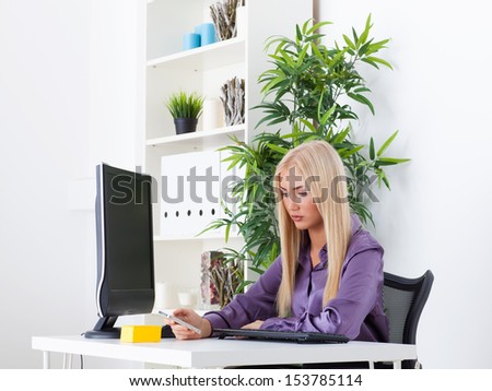 Relaxed businesswoman text messaging in bright office