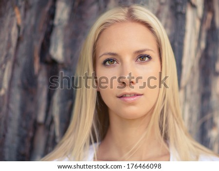 Portrait of the beautiful young woman of the blonde with long hair. Toned in warm colors