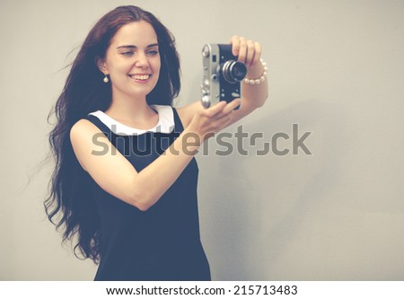 Beautiful sexy brunette with long hair with vintage camera in hand,