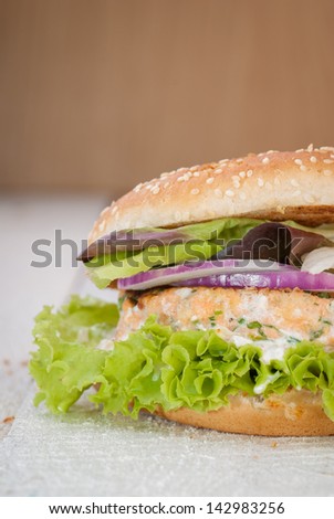 Fish burger. Salmon burger with lettuce and cream of tartar