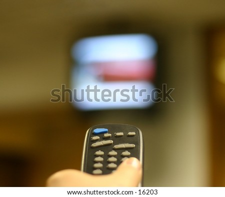 remote control in a hand pointing directly at a high mounted television set