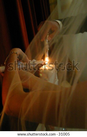 Lighting the unity candle at a wedding through the veil.
