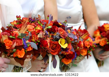 stock photo Red and orange flower bouquet on a wedding dress
