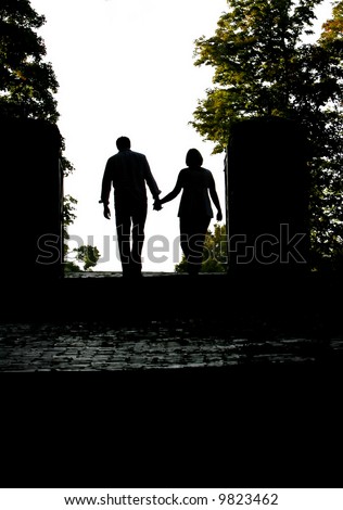 stock photo : silhouette of a couple holding hands walking away