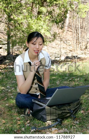 cute asian korean girl outside studying in the park