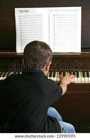 a male youth practicing songs on the piano keys