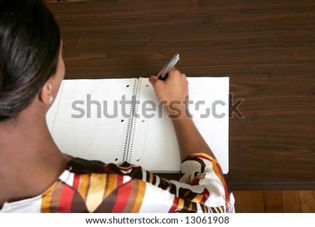 African American female business woman writing on a blank notebook