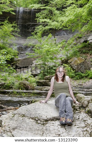 beautiful caucasian woman near a tall waterfall