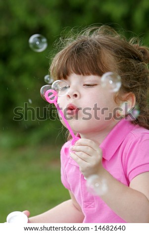 stock photo one young girl child blowing bubbles in a park