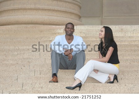 a man and woman two friends talking on the stairs at an old building