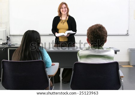 one woman teacher helping two young students in class