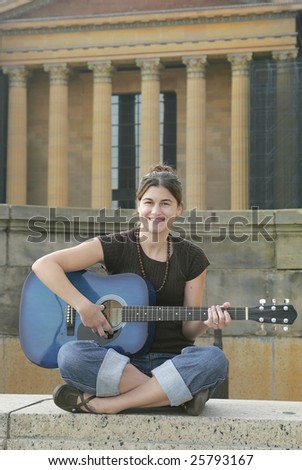one young brunette woman playing a blue guitar