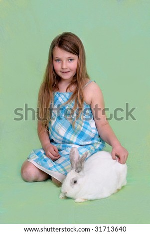 one young pretty child with a white bunny over a pastel colored background