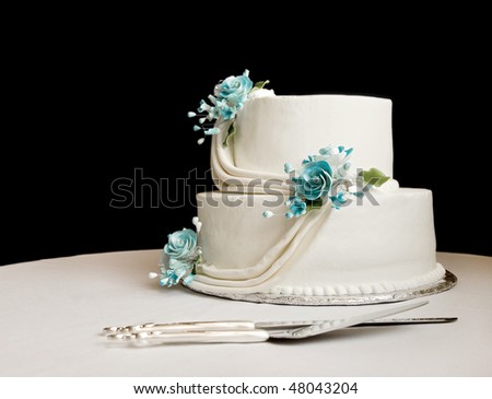 stock photo white wedding cake with blue flowers on a table with a black 