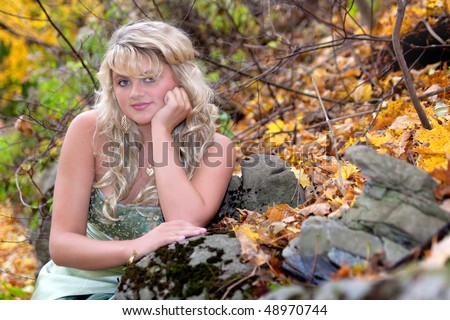young teen blonde girl in a prom dress outdoors with fall colors