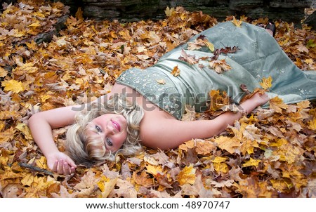 young teen blonde girl in a prom dress outdoors with fall colors